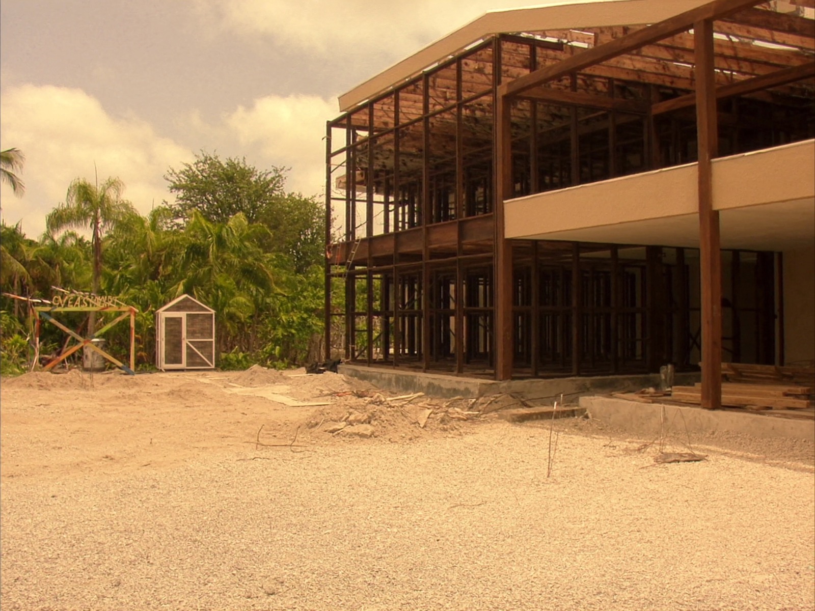 Resort-style commercial building under construction with tropical landscaping