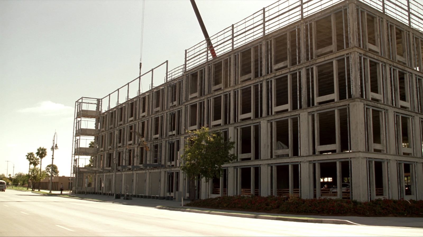 Mid-rise commercial building under construction with a crane in the background